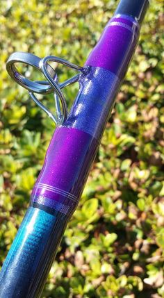 a purple and blue bike handlebar on some bushes