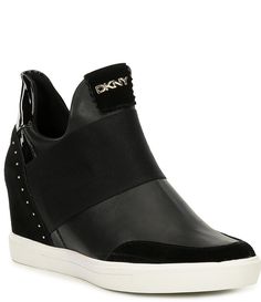 From DKNY&#x2C; the Cailin Leather and Suede Wedge Sneakers feature:Leather upper and suede heel counter Metal stud detailing on heel counter Signature DKNY metal logo detail Elastic band detailSlip-on styling Synthetic lining Rubber outsole Approx. 0.4" platform height Approx. 2.75" heel height Imported. Leather Slip-on Wedge Sneakers, Leather Wedge Sneakers For Spring, Leather Slip-on Wedge Sneakers With Platform, Leather Wedge Sneakers With Platform, Leather Platform Wedge Sneakers Slip-on, Leather Ankle-high Platform Wedge Sneakers, Sporty Leather Wedge Heel Sneakers, Ankle-high Leather Platform Wedge Sneakers, Spring Leather High-top Wedge Sneakers