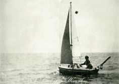 an old black and white photo of a man in a sailboat on the water