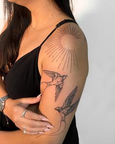 a woman with a bird tattoo on her arm and shoulder is posing for the camera