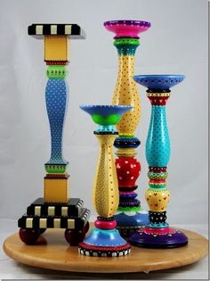 a group of colorful vases sitting on top of a wooden table