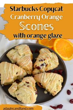 orange scones with cranberry glaze are on a plate next to an orange slice