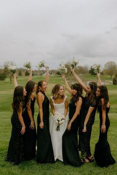 a group of women standing next to each other on top of a lush green field