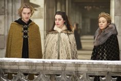 three people standing next to each other on a balcony in medieval clothes and furs