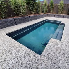 an empty swimming pool in the middle of a backyard