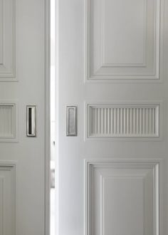 two white doors with metal handles in a room