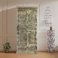 an old wooden door in the corner of a room with a potted plant on the floor