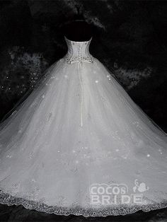 a white wedding dress is displayed on a mannequin headdress in front of a black background