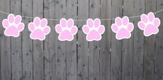 pink paw print bunting on a wooden fence