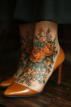 a woman's legs with tattoos and flowers on her leg, showing the foot