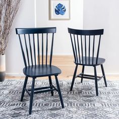 two black chairs sitting on top of a rug