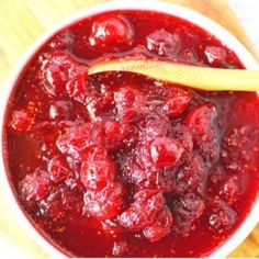 a bowl filled with cranberry sauce and a wooden spoon