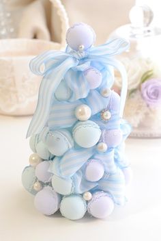 a small blue and white christmas tree with ornaments on it's top, sitting on a table