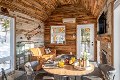 a living room filled with furniture and a fire place under a wooden ceiling covered in wood planks