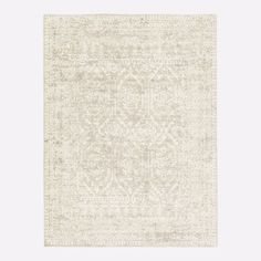 a white rug with an intricate design on the front and back side, in neutral tones