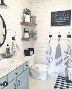 the bathroom is decorated in white and black with plaid towels hanging on the rack above the toilet