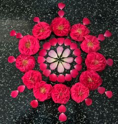 an overhead view of pink flowers on a black surface