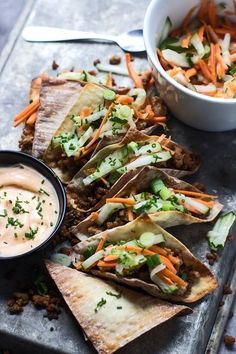 several pita breads on a tray with dip and veggies in the background