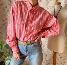 90s vintage flamingo pink boyfriend striped shirt. Cute buttoned collar. Balloon sleeves. The perfect shoulchy and comfy shirt that is menswear but definitely non binary! Material: No composition label. Probably cotton  Very good vintage condition. Suitable size (depending on desired fit as it looks great oversized  Fits best USA16/FR46/3XL/UK18 - USA18/FR48/4XL/UK20 Please refer to one sided laid flat measurements: ❉Shoulders 50cm / 19,6" ❉Inner sleeve 56cm / 22" ❉Pit to pit 64cm / 25,2" ❉Length 76cm / 30" Model is between size USA6/8  FR36/38 - S/M for size reference. ★ GET YOUR FREE SHIPPING BUYING 3 ITEMS OR MORE! ★  To see more gorgeous vintage blouses, click on the link below: https://www.etsy.com/shop/NitnitasheVintage?section_id=36988024 ★ TO ENSURE A SAFE SHIPPING, PLEASE PROVIDE Vintage Pink Shirt With Button Closure, Retro Pink Button-up Top, Retro Pink Shirt With Buttons, Pink Retro Shirt With Buttons, Vintage Pink Shirt With Buttons, Vintage Pink Buttoned Shirt, Vintage Pink Button-up Shirt, Oversized Retro Shirt For Spring, Oversized Pink Vintage Tops