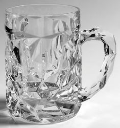 a glass mug that has been cut into pieces and is sitting on a white surface