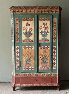 an old painted cabinet with flowers on it