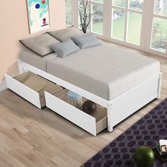 a bed with two drawers underneath it in a room next to a window and rug