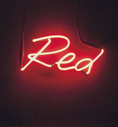 a red neon sign hanging from the side of a building