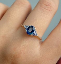 a woman's hand with a blue ring on it