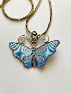 This is an absolutely beautiful vintage David Anderson, Norway, gold over sterling silver Vermeil Guilloche Blue butterfly pendant necklace.  The blue Guilloche enamel butterfly is shades of periwinkle, blue light, blue, and almost a purple color. The back of the butterfly is signed David Anderson, Norway, Sterling 925S The chain, which I believe is a marriage, is marked Danecraft  Italy 925. It is gold over sterling silver Vermel. The butterfly pendant, the bale, measures 1 1/4 inches wide and Unique Blue Engraved Jewelry, Blue Engraved Enamel Jewelry, Collectible Blue Engraved Necklace, Blue Enamel Engraved Jewelry, Blue Engraved Necklace Collectible, Blue Engraved Enamel Necklaces, Blue Enamel Engraved Necklace, Blue Jewelry With Butterfly Charm For Jewelry Making, Unique Blue Butterfly Jewelry