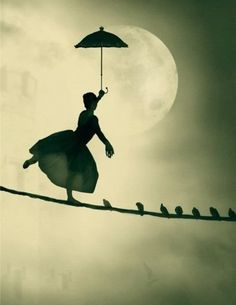 a person walking on a tightrope with an umbrella