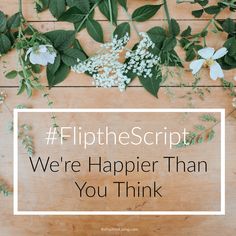 flowers and greenery on a wooden surface with the words flipthe script we're happier than you think