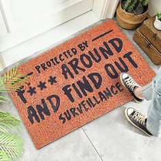 someone is standing on the door mat that says protect by around and find out surveillance