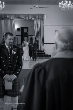 a man in a kilt walking down the aisle