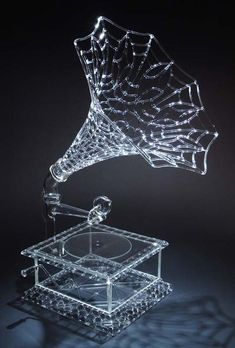 a glass record player with its lid open and lights on it's side, in the shape of a spider web