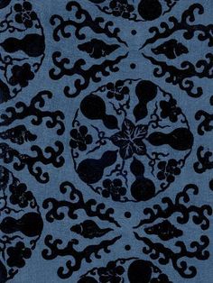 a blue and black fabric with an intricate design on the front, in dark colors