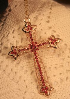 This goldtone necklace features a lovely mid-to-large-sized pectoral cross pendant with lots of sparkle and shine!  It has a lacy filigree finish with petalled ends to the arms.  It shines with bright ruby red rhinestones that capture the light beautifully!  The back has a shiny finish and it measures 2 1/2 inches wide and 3 3/4 inches long (including the loop).  The chain is 24 inches and closes with a safety catch. Gold Cross Necklace For Party, Pectoral Cross, Red Rhinestone, Ear Jewelry, Ruby Red, Cross Pendant, Pendant Necklaces, Favorite Jewelry, Necklace Etsy