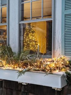 a window sill decorated with christmas lights and greenery