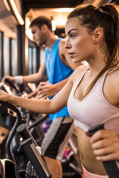 two people on exercise bikes in a gym