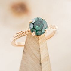 a close up of a ring with a green stone on it's center piece