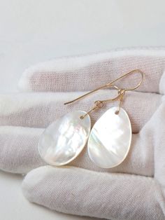 White Mother of Pearl Shell Earrings. Hand selected and matched drops. A beautiful rainbow iridescence in the light with every movement. A great "go to" earring, naturally very lightweight and can be worn with anything. High quality French ear wires either 14k solid gold or 14k gold filled or 14k Rose Gold Filled or Sterling Silver is available. Teardrop size is 18x28mm, earrings hang 1.8 inches. The mannequin shows the relative size and how they will hang. Please check out my store for more gem White Teardrop Mother Of Pearl Jewelry, High Luster Teardrop Pearl Earrings, Elegant Iridescent Jewelry For Pierced Ears, High Luster Drop Pearl Earrings For Gift, Elegant Iridescent Drop Jewelry, Teardrop Mother Of Pearl Ear Wire Jewelry, Pearl White Drop Jewelry With High Luster, White Drop Earrings In 14k Gold Filled, Drop-shaped Mother Of Pearl Jewelry For Gifts