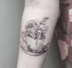 a woman's arm with a flower pot tattoo on it