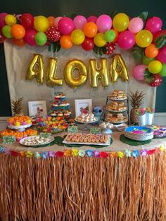 a table topped with lots of food next to a sign that says aloha