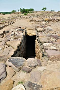 an open hole in the ground surrounded by rocks