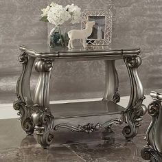 a silver table with flowers and a vase on top