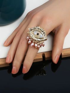 Introducing our "All-Seeing Eye Ring," a bold and striking statement piece designed for those who embrace the extraordinary. This unique ring features a meticulously crafted eye at its center, adorned with delicate pearl and crystal embellishments that cascade like tears, adding a touch of mystique and drama to any look. The ring is crafted from high-quality alloy and finished with a luxurious gold plating, ensuring both durability and a radiant shine. Details: - Material: High-quality alloy, faux pearl, and crystal accents- Ring size: Adjustable to fit most sizes comfortably- Eye design dimensions: Approximately 3.5 cm in width- Weight: 34g per piece- Eye motif with pearl and crystal 'tears' for a dramatic and elegant aesthetic The All-Seeing Eye Ring is a perfect addition to your collect Crystal Tears, Eye Motif, Elegant Aesthetic, All Seeing Eye, Eye Ring, Unique Ring, Eye Design, Crystal Embellishment, Unique Rings