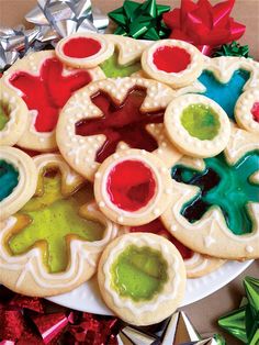 decorated cookies on a plate surrounded by christmas tinsels