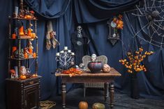 a living room decorated for halloween with decorations and pumpkins on the table in front of it