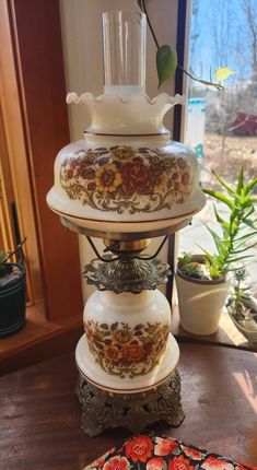 three tiered vases on top of each other in front of a potted plant