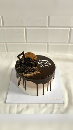 a birthday cake with chocolate icing and cookies on top