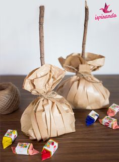 two bags filled with candy sitting on top of a wooden table next to some sticks